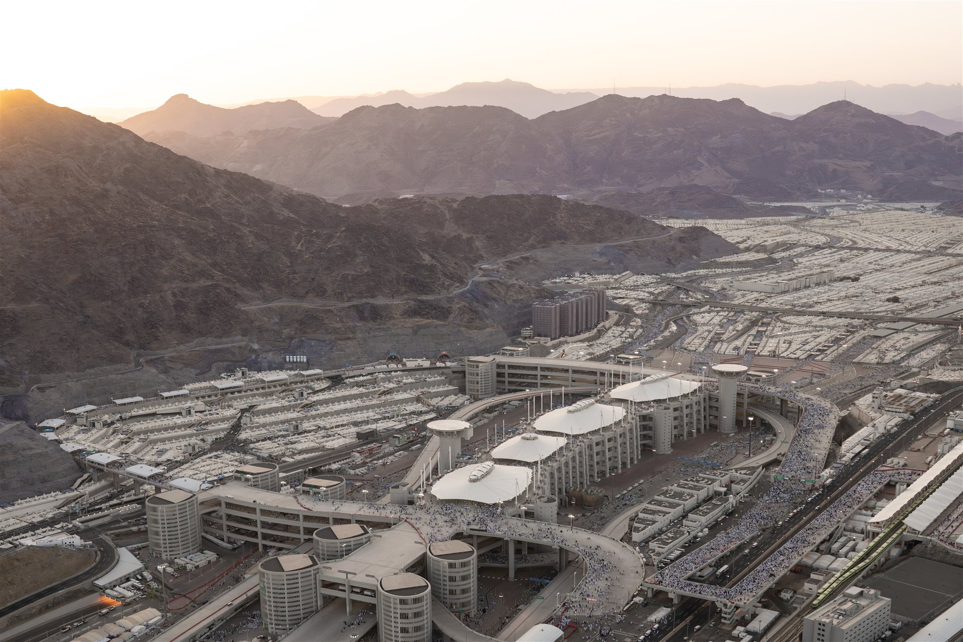 Aerial view of the multilevel Jamarat complex, surrounding pedestrian routes, and Mina's tent city.